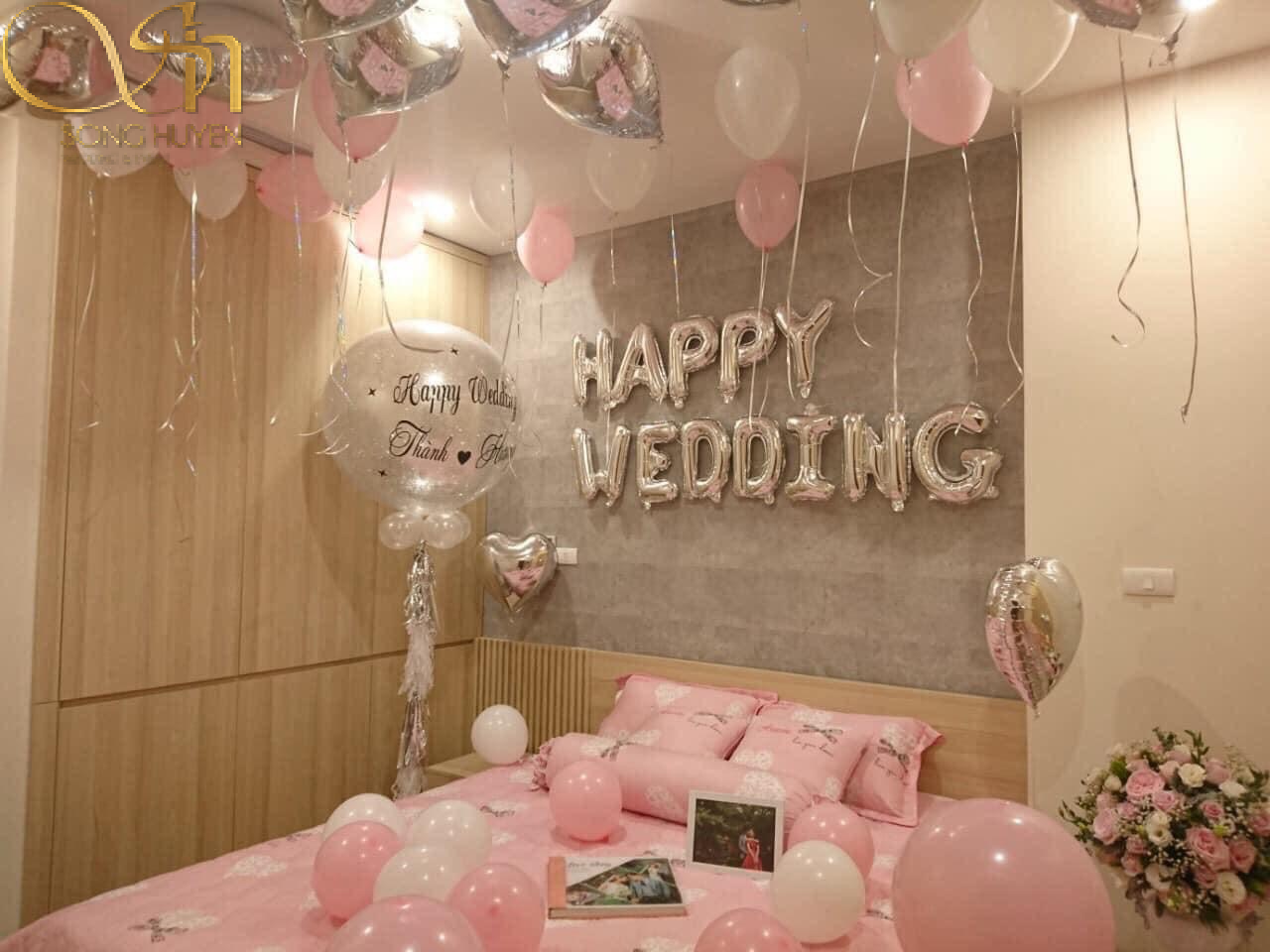 Hai màu trắng hồng hòa, album ảnh và chữ Happy Wedding đã trang trí phòng một phòng tân hôn ấm áp và vô cùng đáng yêu 